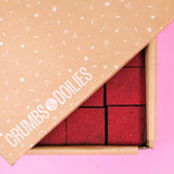 Raspberry & Dark Chocolate Brownie by Crumbs & Doilies in branded box, rich red velvet texture visible inside.